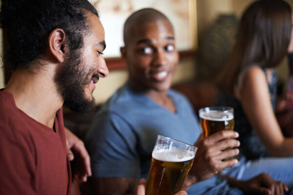 Friends, beer and chill at pub, smile and relax indoor for conversation and bonding at night to celebrate. Male people, bar and happy for social, guys and alcohol together and laughing for fun