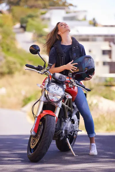 Woman, motorcycle and relax with helmet in city for ride, road trip or outdoor sightseeing in nature. Extreme female person, biker or rider chilling on motorbike or vehicle for transport or journey.