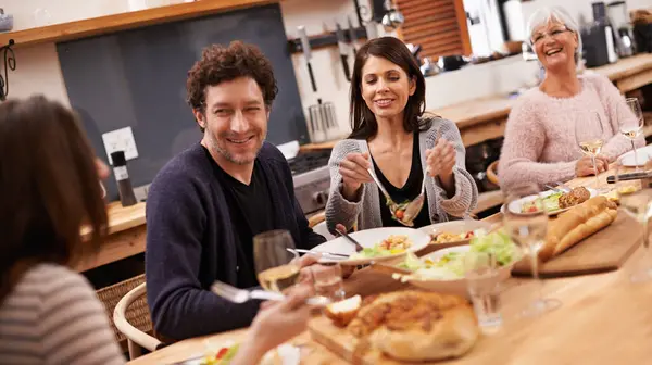 Laughing, conversation and family at dinner in dining room for party, celebration or event at modern home. Smile, bonding and people enjoying meal, supper or lunch together with wine at house