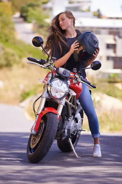 Woman, motorcycle and relax with helmet on road in city for ride, trip or outdoor sightseeing in nature. Extreme female person, biker or rider sitting on motorbike or vehicle for transport or journey.