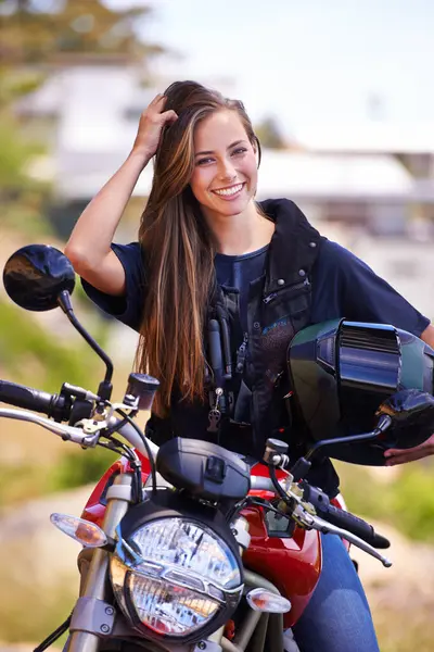 Portrait, helmet and outdoor with woman, motorbike and extreme sports with adventure and safety. Face, person or girl with transport and travel with road trip and journey with rider, joyful and happy.