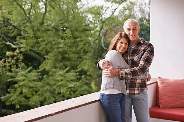 Senior couple, hug and portrait on balcony with happy, love and outdoor with connection for retirement. Woman, elderly man and embrace on patio with pride, care and smile at apartment in Germany.