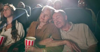 Sinema, sinema ve mutlu film için gülümseyen yaşlı çift, rahatlayın ve tiyatroda uyuyun. Mutluluk, yaşlılar ve eğlence, tarih ve emeklilik için patlamış mısırla dinlenmek..