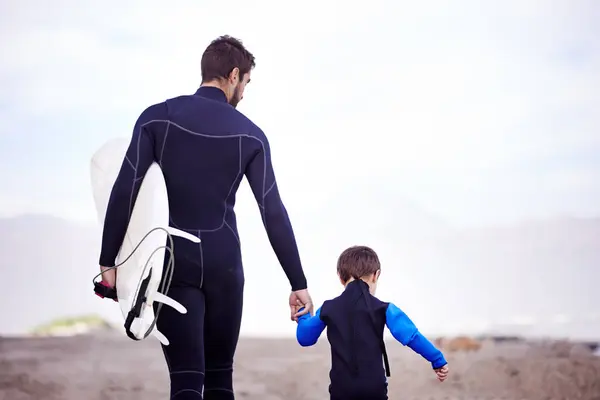 サーフボード 男と子供 ビーチで手を握り アウトドアボンディングアドベンチャーを歩いています サーフィン サポート 成長と共に学ぶための海洋での自然 — ストック写真