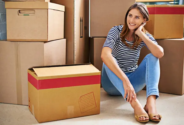 Thinking, smile and woman with boxes in new home for moving to estate, property or apartment. Happy, excited and young female person with cardboard package for equipment and products in modern house