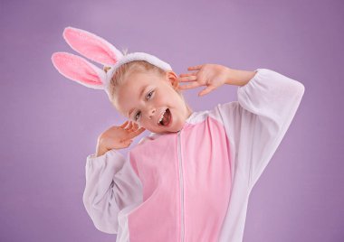 Portre, tavşan ve kostümlü kız, heyecanlı ve cadılar bayramı kıyafeti mor stüdyo arka planında. Yüzü, çocuğu ya da mankeni tavşan gibi giyinmiş ve karakterli ya da ifadeli ya da komik Paskalyalı..