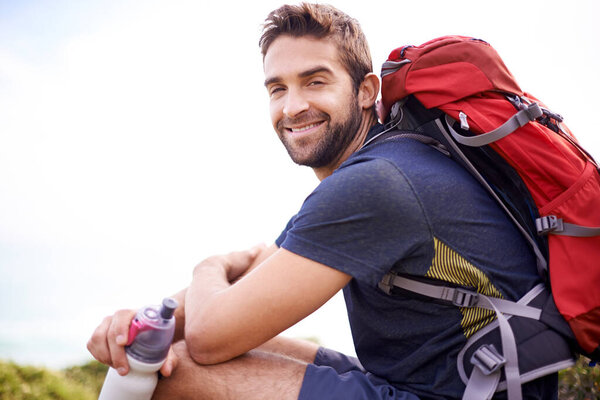 Man, hike and smile for adventure with water bottle or backpacker for fitness, workout and activity on mountain top. Portrait, happy and outdoor in nature for healthy mind in woods or forest