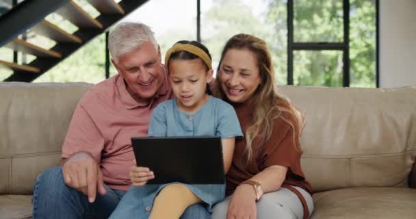 アプリ ゲーム テクノロジーとしての子供 祖父母 またはタブレットは ソファーで学習したり楽しんだりします タッチスクリーンでおじいちゃん おばあちゃん おばあちゃん または女の子は — ストック動画