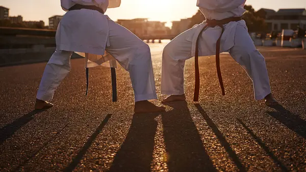 People, karate and legs with martial arts in self defense, class or teaching in the city street. Outdoor fighter, athlete or sparring partner in fitness training, kata or technique in an urban town.