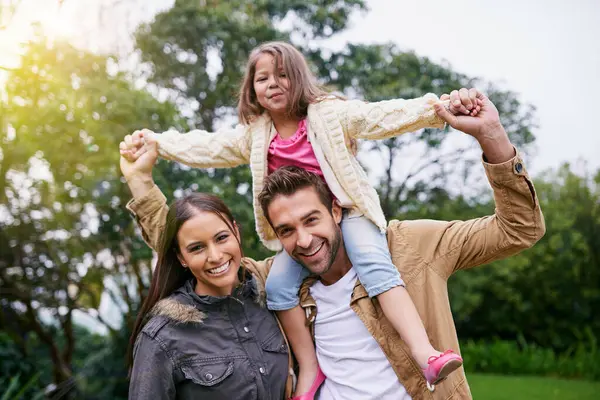 Mother, father and child in portrait in park with love, bonding and support at outdoor family adventure. Smile, parents and girl walking in garden together with happy man, woman and kid in nature.