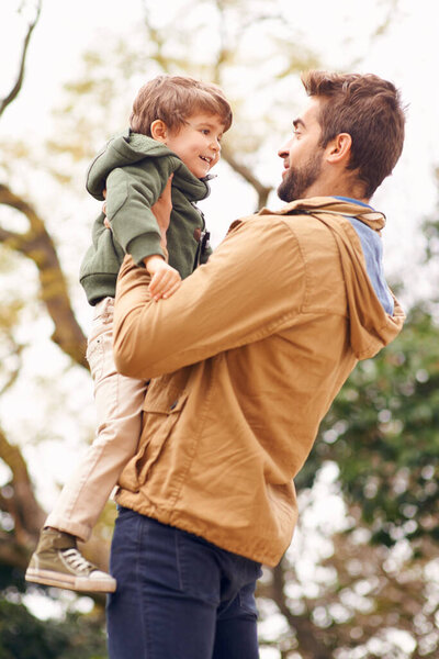 Father, child and love embrace in nature for bonding connection in forest for autumn happiness, joy or care. Male person, son and holding in woods for holiday vacation or outdoor, family or together.