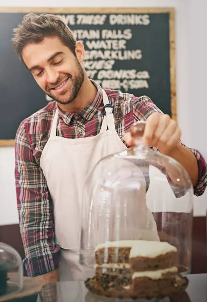 Man, waiter and cake on counter in coffee shop for display, service and catering with smile in morning. Person, barista or business owner in cafe, bakery or diner with pride, ideas and snack in Italy.