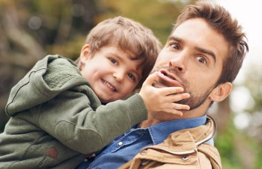 Baba, oğul ve çocuk gelişimi için oynamak ve aile kadar aptalca eğlenmek için açık havada kaynaşmaktan mutlu. Portre, baba ve çocuğun gülümsemesi ile okul tatilinde bakımı, büyümesi ve eğlenmesi için.