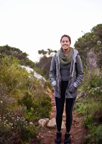 Woman, hiking and happy in nature for portrait on path with fitness, outdoor or adventure on holiday. Girl, person and smile for trekking in bush, hill and rocks for journey on vacation in Cape Town.