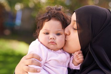 Güney Afrika 'da Cape Town' da bayram sırasında, Müslüman bir kadın, anne ve bebek aşk, ilgi ve yakınlık için öpüşüyorlar. Kadın, çocuk ve aile birlikte doğada, bahçede ve arka bahçede sevgiyle.