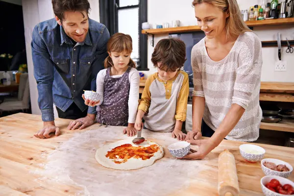 Happy Perhe Ruoanlaitto Pizza Keittiössä Yhdessä Laskuri Leivonnaisia Kastiketta Italialaista — kuvapankkivalokuva
