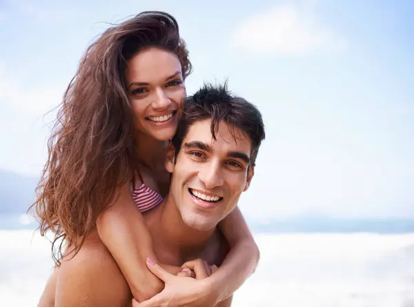 Piggyback, ocean and portrait of couple at beach on vacation, adventure or holiday for romantic travel. Happy, love and young man and woman on date by sea for tropical anniversary weekend trip