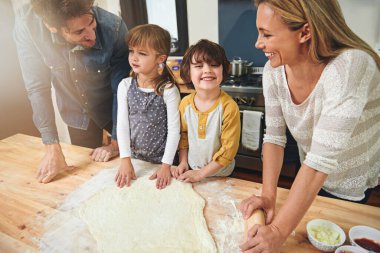 Öğrenmek, mutlu olmak ve ailece mutfakta yemek pişirmek, evde kaynaşmak ve gülümsemek. Pizza, anne ve baba ve çocuklar yemek pişirir, öğretmenlik yapar ve ailelere un hamuru hazırlamada yardım eder..