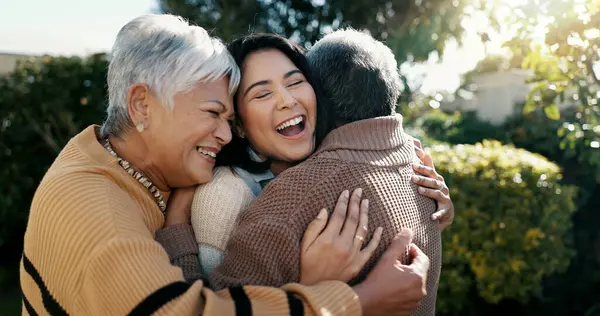 Mexican family, hug and smile for reunion, outdoors and love for support, retirement and care. Elderly parents and daughter, visit and happy in backyard, bonding and embrace for quality time at home.