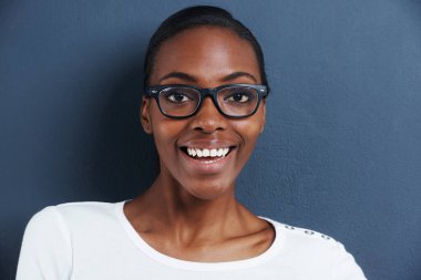 Siyah kadın, portre ve gözlük stüdyoda çerçeveli, gülümseme ve optometri için moda gözlük. Model, yüz ve Afrikalı gözlüklü, vizyonlu ve mavi arka planda olduğu için mutlu..