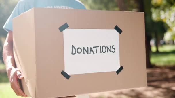 ボックス 貧しいコミュニティに与えるために服や食べ物の容器に手で慈善団体に与える ダンボールパッケージで屋外を支援する非営利団体のオファー サポート ボランティアの人 — ストック動画