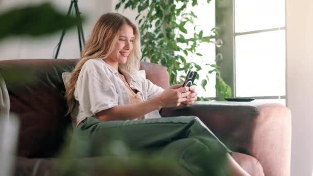 Vrouw Glimlach Breek Met Smartphone Ontspannen Rusten Huis Appartement Woonkamer — Stockvideo