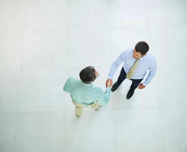 仕事に行きましょう オフィスで握手している二人のビジネスマンの高い角度のショット — ストック写真