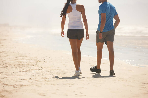 Couple, fitness and walking on beach with partner for workout, exercise or training together in nature. Rear view of active man and woman in stroll, cardio or health and wellness on the ocean coast.