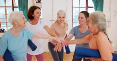 Çak bir beşlik, yoga ve stüdyodaki yaşlı kadınlar sağlık, sağlık ve vücut çalışmalarını kutlamak için. Bir yığın el, mutlu ve yaşlı bayan arkadaşlar spor merkezinde birlikte pilates yapıyorlar.
