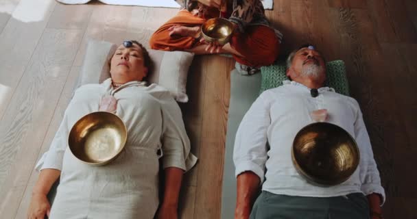 在整体练习中 用西藏歌唱碗进行声音 冥想和放松 以达到精神上的健康愈合 音乐和夫妻聆听金属乐器的震动 以平衡禅师的脉轮 — 图库视频影像