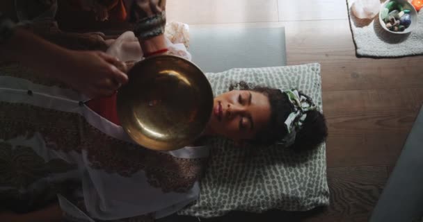 在整体练习中 用西藏歌唱碗进行声音 冥想和放松 以获得健康或精神上的愈合 音乐和女人聆听乐器的震动以平衡来自上方的脉轮 — 图库视频影像