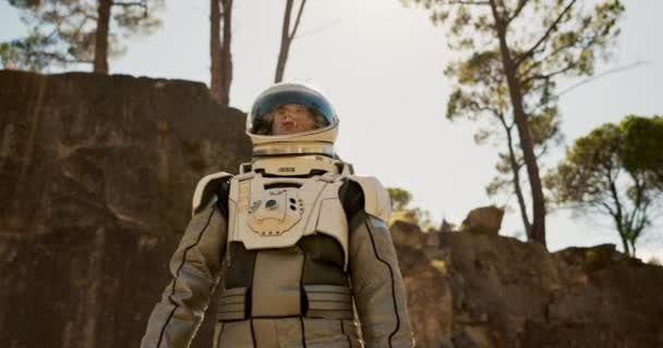 宇宙飛行士は 放棄された地域 宇宙を探索するために森の中を歩いています 宇宙スーツ 未来的なファンタジー 旅のためのエイリアン環境の人 — ストック動画