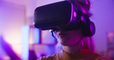 Oyun, sanal gerçeklik gözlükleri ve eğlence, online oyunlar ve esportlar için gece kumandalı bir kadın. Oyuncu, neon ışığı ve metaevren, siber dünya ve rekabet için VR gözlükleri olan kişi.