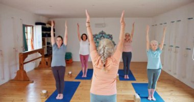 Kıdemli kadın, antrenör ve yoga sınıfında Zen, manevi sağlık ve denge için esneme hareketleri. Yaşlılar, yoga ya da spor koçu olan grup ya da yaşlılar paspasın üzerinde farkındalık içinde egzersiz ya da pilates yaparlar..