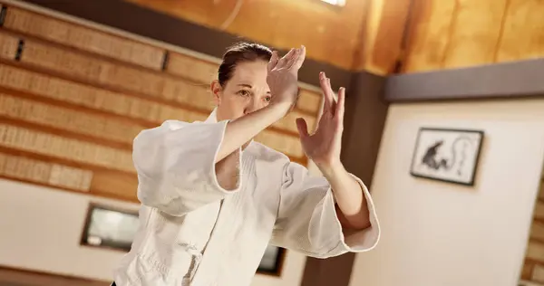 Aikido class, woman and fight for martial arts, strike or together for combat at training, gym or dojo. Japanese person, student and hands for exercise, workout or fitness with zen, conflict or club.