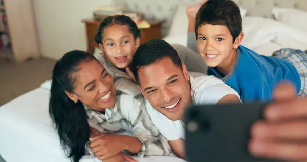 电话和家人一起睡在床上 为快乐的肖像画 记忆和社交媒体贴上亲密 美好的时光或周末 妈妈和孩子们在卧室里醒来 放松一下 — 图库照片