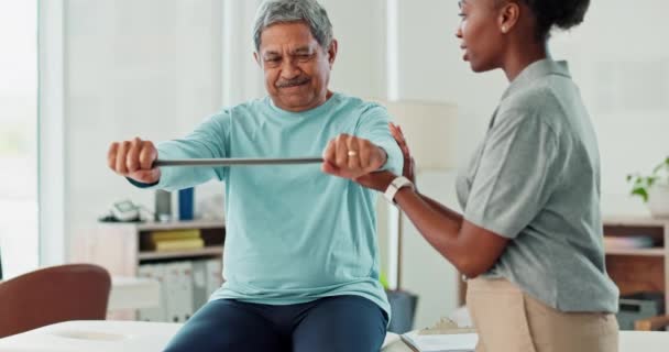抵抗バンド 理学療法および筋肉回復との相談のためのクリニックのシニアマン 女性の身体療法士は 腕の運動を伸ばす高齢男性患者を助ける — ストック動画