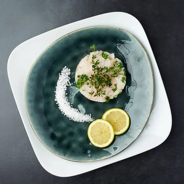 Dinner, menu and plate of seafood at fine dining restaurant with lemon, salt and herbs on fish. Healthy, cooking and luxury dish with protein from gourmet fillet of tuna for nutrition in diet.