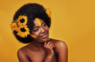 Siyahi kadın, stüdyo ve doğal ayçiçekleriyle mutlu cilt bakımı ve Afrikalı model ve afro ile dinlenme. Bencillik, organik kozmetik ürünleriyle güzellik, sarı arka planda cilt bakımı..