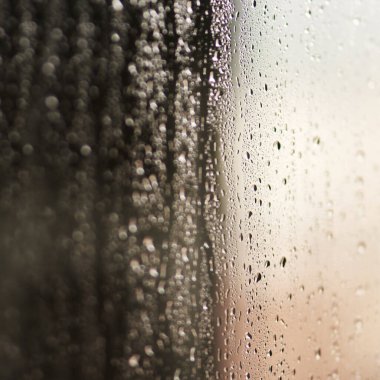 Yüzeyinde buhar, doku ve duvar kağıdı veya soyut ekran koruyucusu olan cam, su veya yağmur damlaları. Penceredeki nem, nem veya sıvı baloncuk, yoğunlaşma ve sisli damlacık veya yansıma.