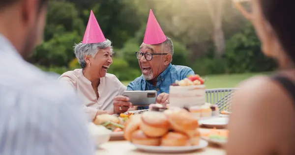Senior, couple and happy with video call at birthday party for celebration, laughing and memories in garden. Elderly, man and woman with smartphone for photography, gathering and event in backyard.