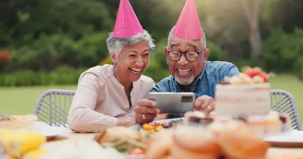 Elderly, couple and happy with video call at birthday party for celebration, laughing and memories in garden. Senior, man and woman with smartphone for photography, gathering and event in backyard.