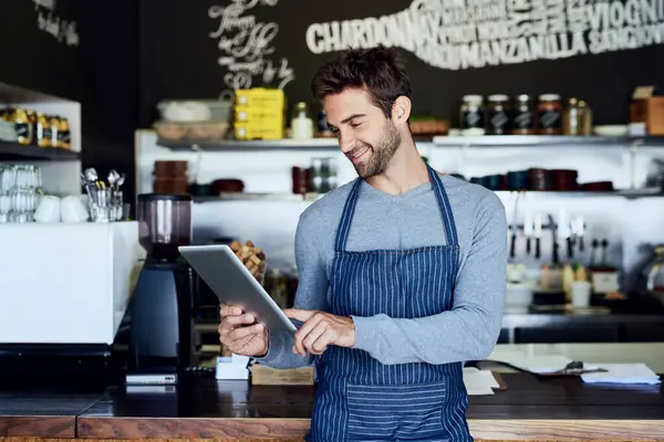 Küçük işletme, kafeterya ve tabletli adam internet, internet ya da kafede rezervasyon kontrolü yapıyor. Hizmet borsası raporu için dijital uygulaması olan ağ oluşturma, gülümseme ve restoran yöneticisi, garson veya sahibi.