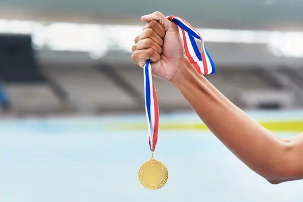 Medal, winner and athlete at outdoor stadium podium for competition success, achievement or motivation. Champion, gold award and celebration of running contest for fitness, health and wellness.