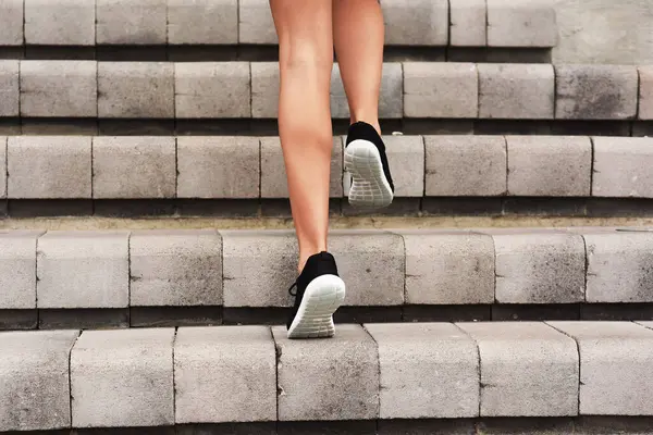 Athlete, feet and run for person on stairs, exercise and training for marathon competition. Runner, sports and workout for wellness and health on steps, cardio and footwear for endurance hit fitness.