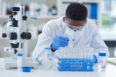 Bilim, test tüpleri ve siyah adam laboratuarda araştırma ve tıbbi ekipmanlarla deney yapıyor. Adli tıp ve araştırma için sağlık ve eğitime sahip Afrikalı kişi, çalışan ve bilim adamı.