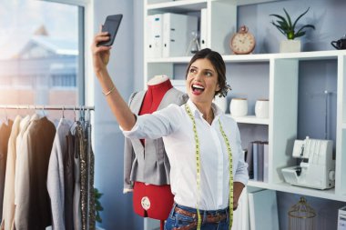 Selfie, kadın ve tasarımcı moda, markalaşma ya da tekstil sektöründe yaratıcı kariyer için dikiş odasında mutludur. Tasarım stüdyosu, atölye ya da butikte sosyal medya için kıyafeti olan bir terzi..