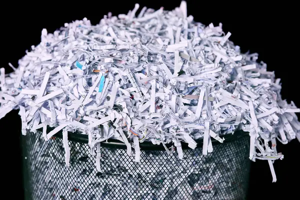 Business, bin and shred of paper, report or top secret in document, information or evidence in waste. Destruction, page or classified in policy, tear and privacy with cut up trash on black background.