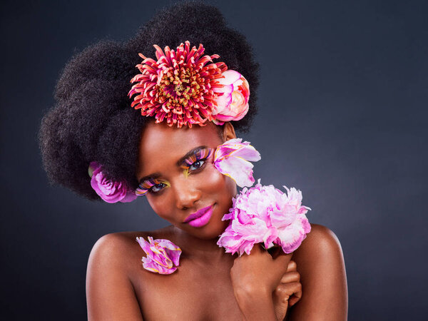 Beauty, flowers and portrait of natural black woman in studio on dark background for cosmetics. Face, makeup or skincare and young afro model with protea in hair for aesthetic wellness at spa.