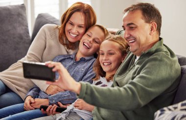 Sosyal medya, post ve tatil anıları için oturma odasındaki kanepede mutlu, aile ve selfie. Çevrimiçi güncelleme, mutluluk ve sevgi için evde dijital fotoğrafçılığa sahip anne, çocuk ve baba.